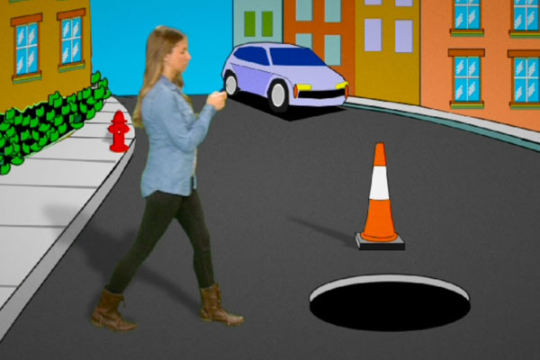 teen walking toward a manhole while texting on her cell phone