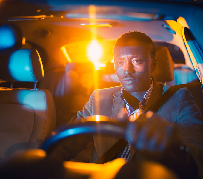 man driving at night looking tired