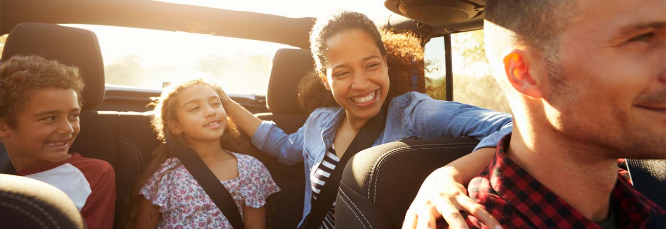 mixed ethnic family in car, focus on backseat passengers