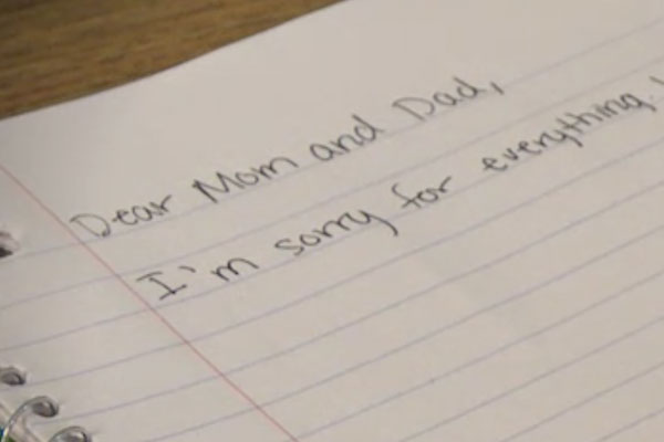close up of a ruled notebook with "dear mom and dad"