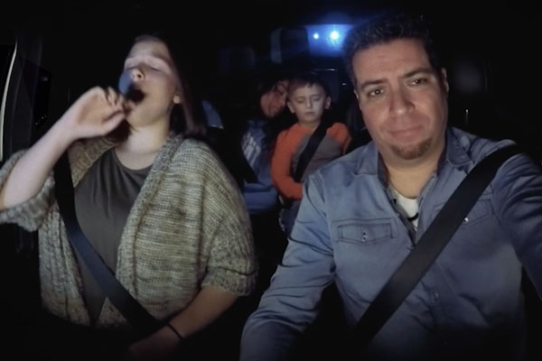a family in a car driving at night and tired