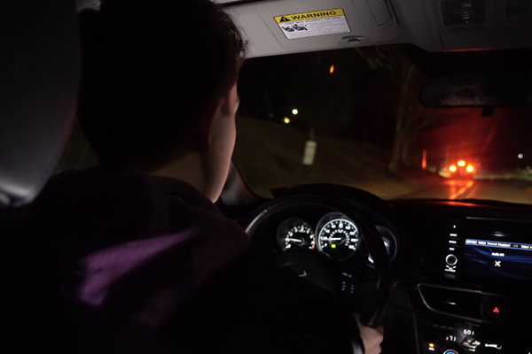 a teen driving at night view from behind the driver seat